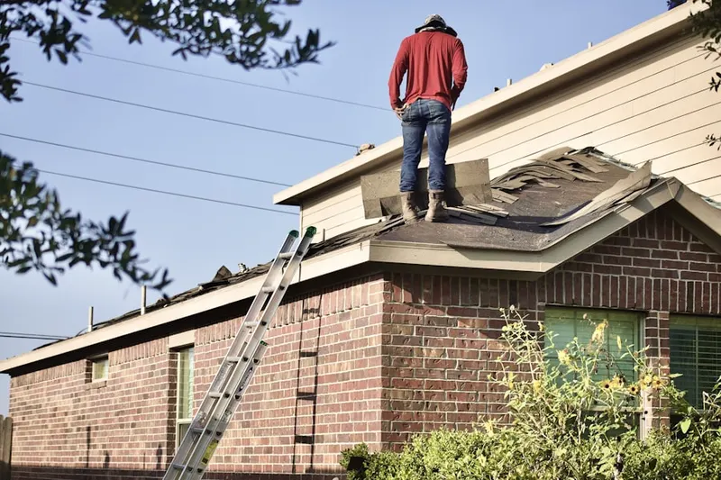 Professional roofer working on a residential roof in East Littleton